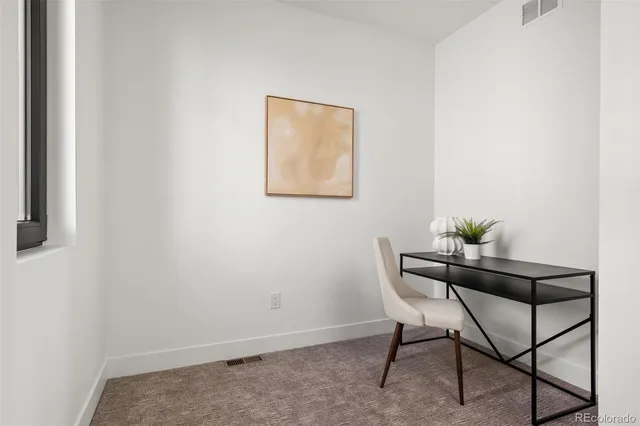 a dining room with furniture and a potted plant