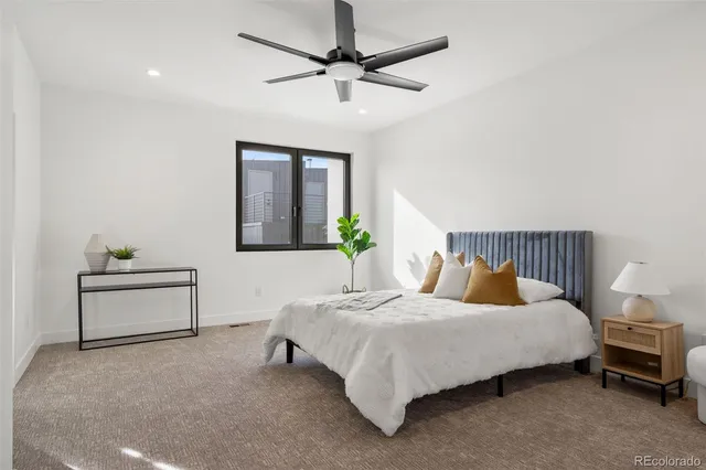 a bedroom with a bed table and a potted plant