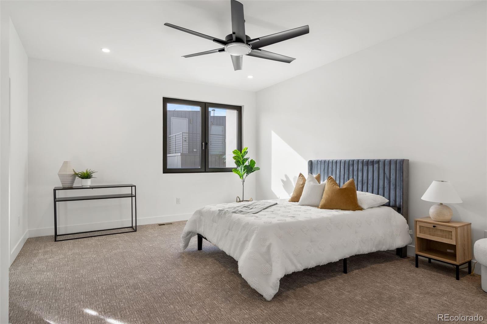 1256 Yates Street Denver, CO 80204 - Photo 19 of 26 a bedroom with a bed table and a potted plant