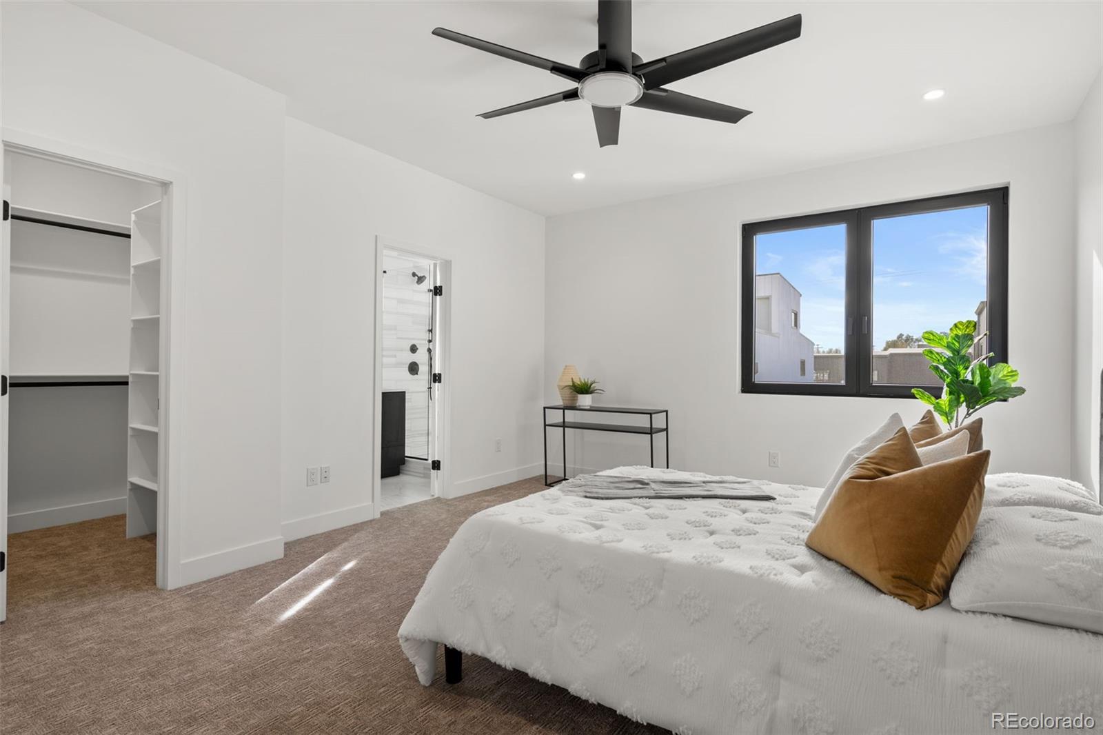 1256 Yates Street Denver, CO 80204 - Photo 20 of 26 a bedroom with a large bed and a chandelier