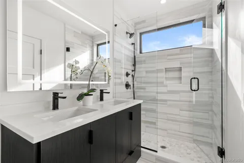 a bathroom with a sink shower and a mirror
