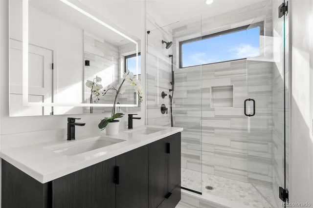 a bathroom with a sink shower and a mirror