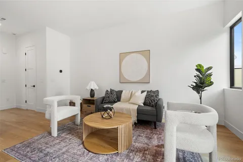 a living room with furniture a couch and a potted plant