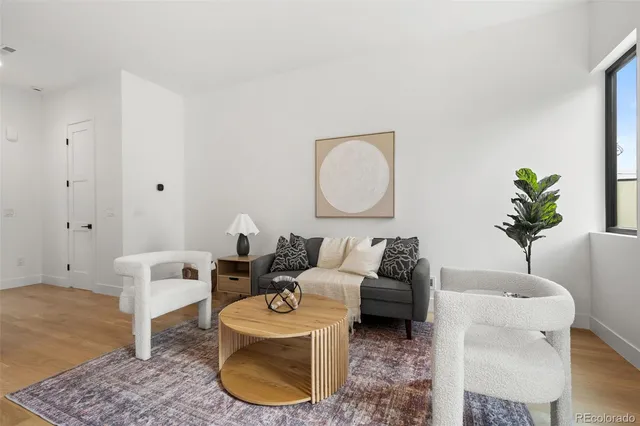 a living room with furniture a couch and a potted plant