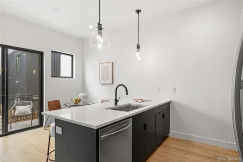 a kitchen with a sink a counter space and a chandelier