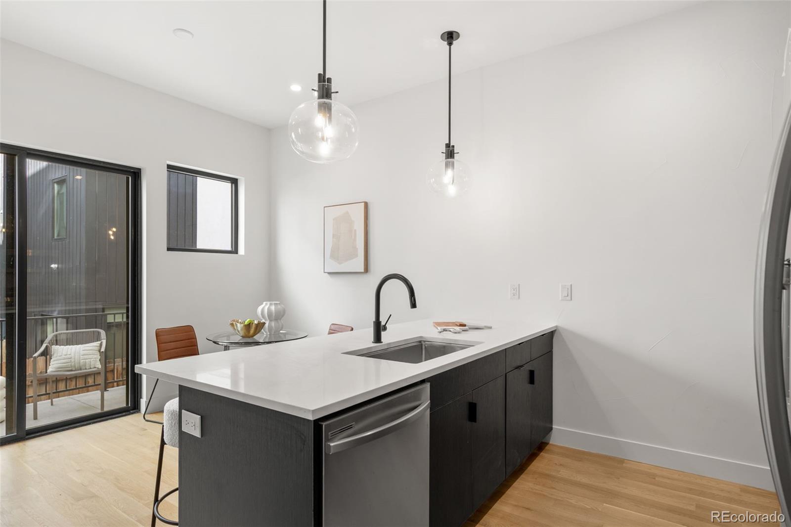 1256 Yates Street Denver, CO 80204 - Photo 10 of 26 a kitchen with a sink a counter space and a chandelier