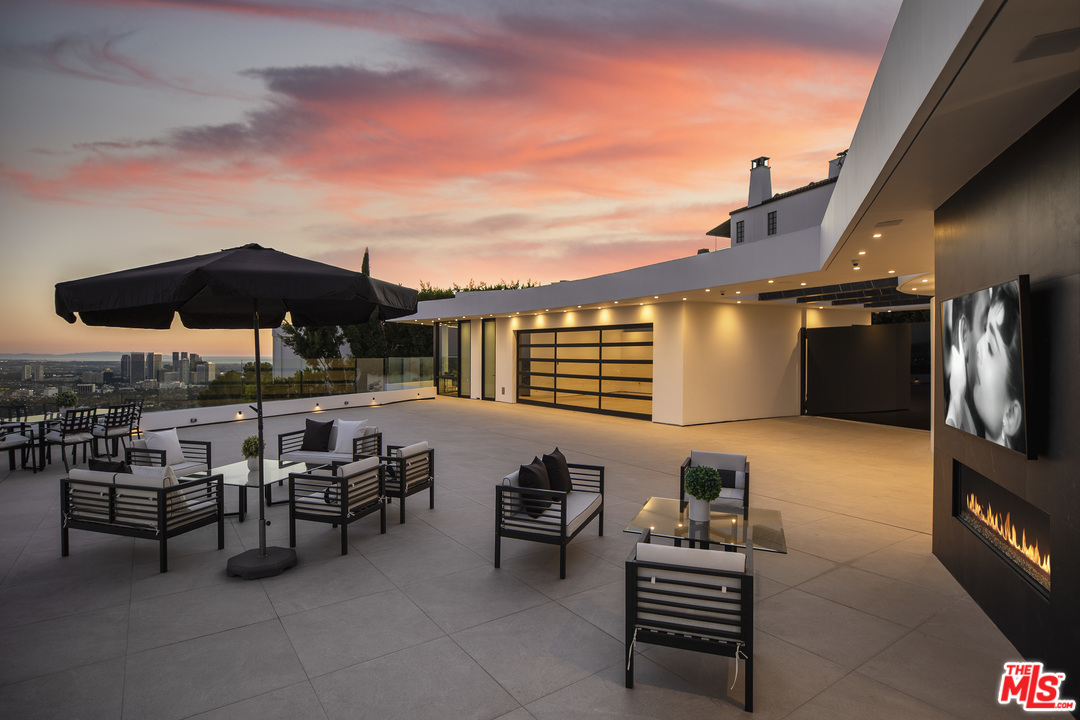 9364 Beverlycrest Drive Beverly Hills, CA 90210 - Photo 17 of 18 a roof deck with table and chairs under an umbrella with a barbeque