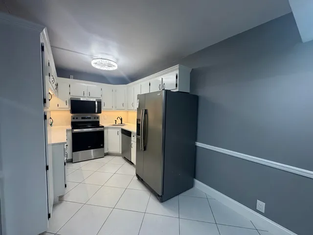 a kitchen with cabinets appliances and a sink