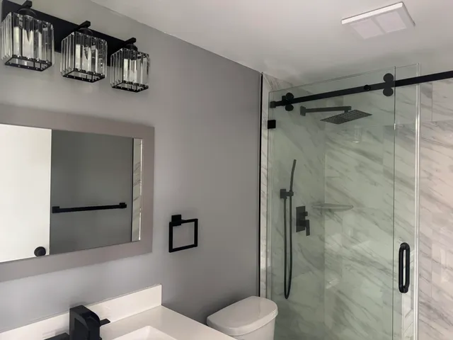 a bathroom with a toilet a sink and shower