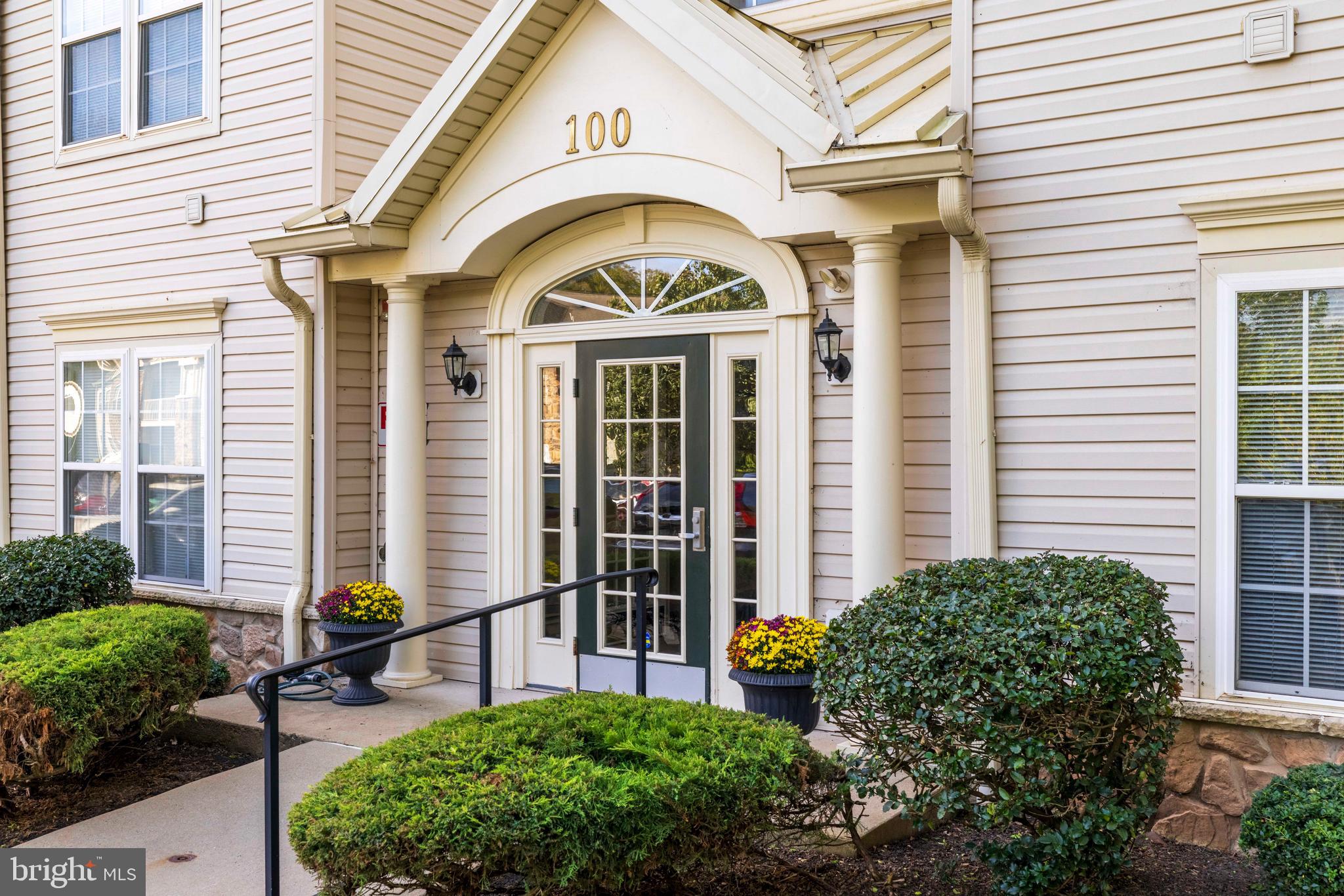 a view of a brick house with potted plants and a table and chairs