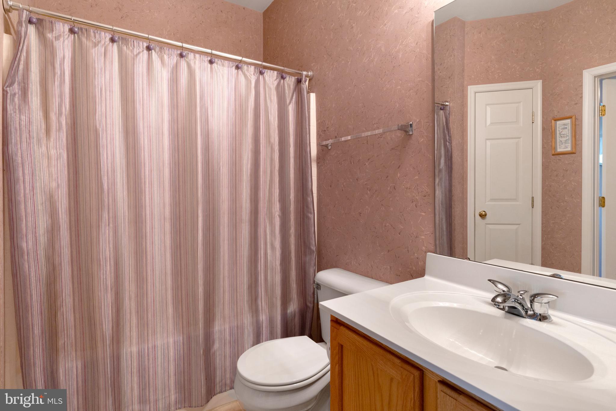 100 Fiddleleaf Lane, Unit 104 Warrington, PA 18976 - Photo 15 of 20 a bathroom with a sink a toilet and shower curtain