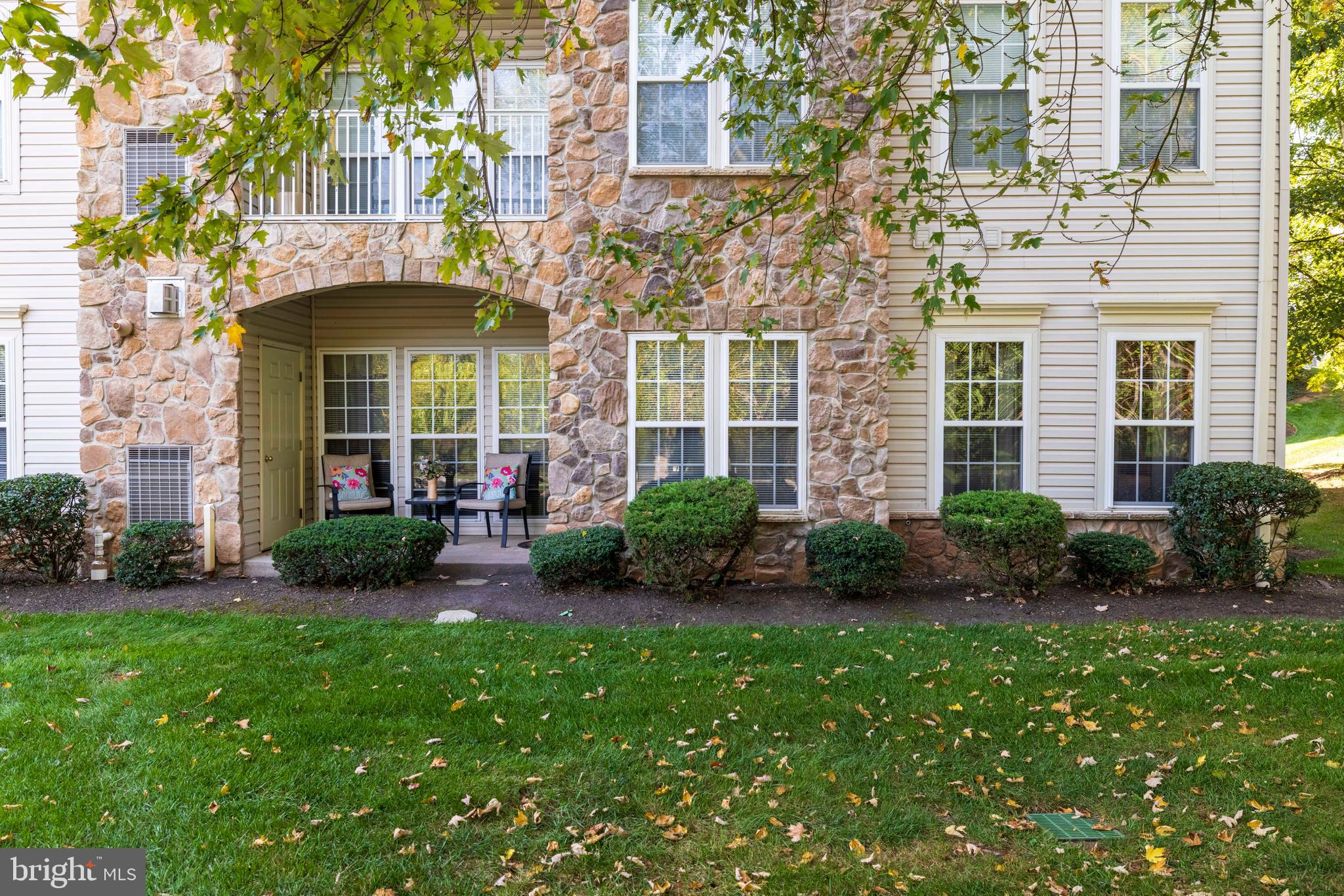 100 Fiddleleaf Lane, Unit 104 Warrington, PA 18976 - Photo 16 of 20 a view of a brick house with a yard and plants