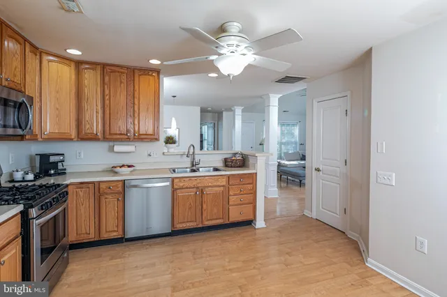 a large kitchen with cabinets a sink and stainless steel appliances