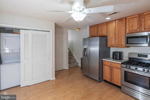 a kitchen with stainless steel appliances granite countertop a refrigerator a stove and a sink with cabinets