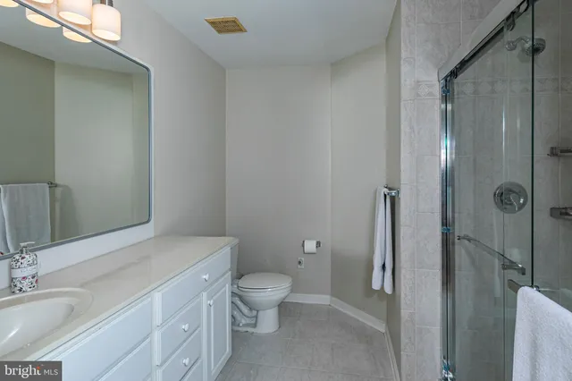 a bathroom with a granite countertop toilet a sink and a mirror