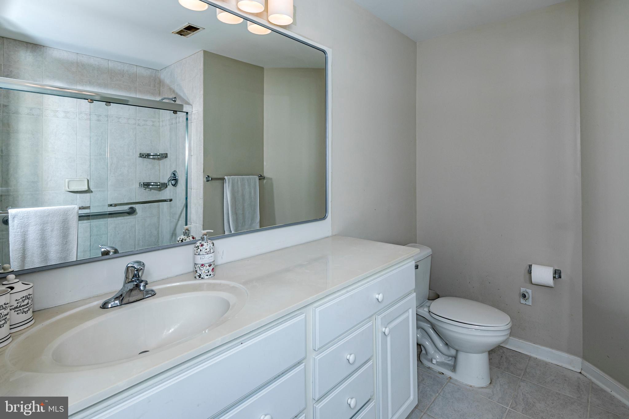 163 Federal Point Boulevard Lawrence Township, NJ 08648 - Photo 21 of 37 a bathroom with a granite countertop sink a toilet and a mirror