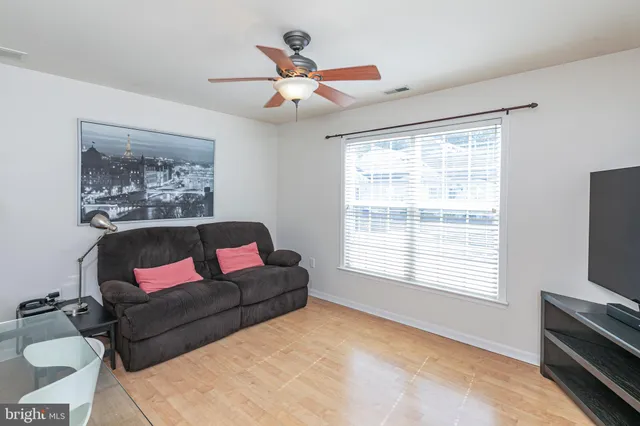 a living room with furniture a flat screen tv and a window