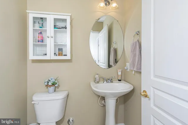 a bathroom with a sink toilet and a mirror