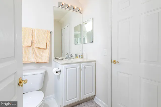 a bathroom with a granite countertop toilet sink and mirror