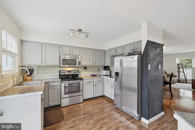 a kitchen with stainless steel appliances granite countertop a refrigerator stove and sink