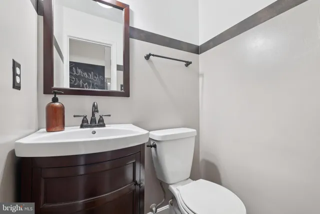 a bathroom with a sink vanity mirror and toilet