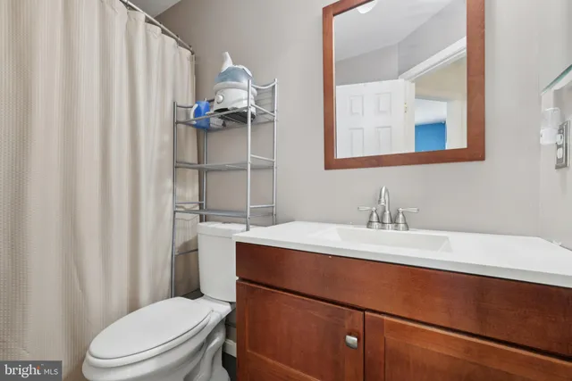 a bathroom with a sink a toilet and a mirror