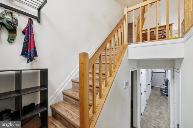 a view of staircase with lots of stuff and hardwood floor
