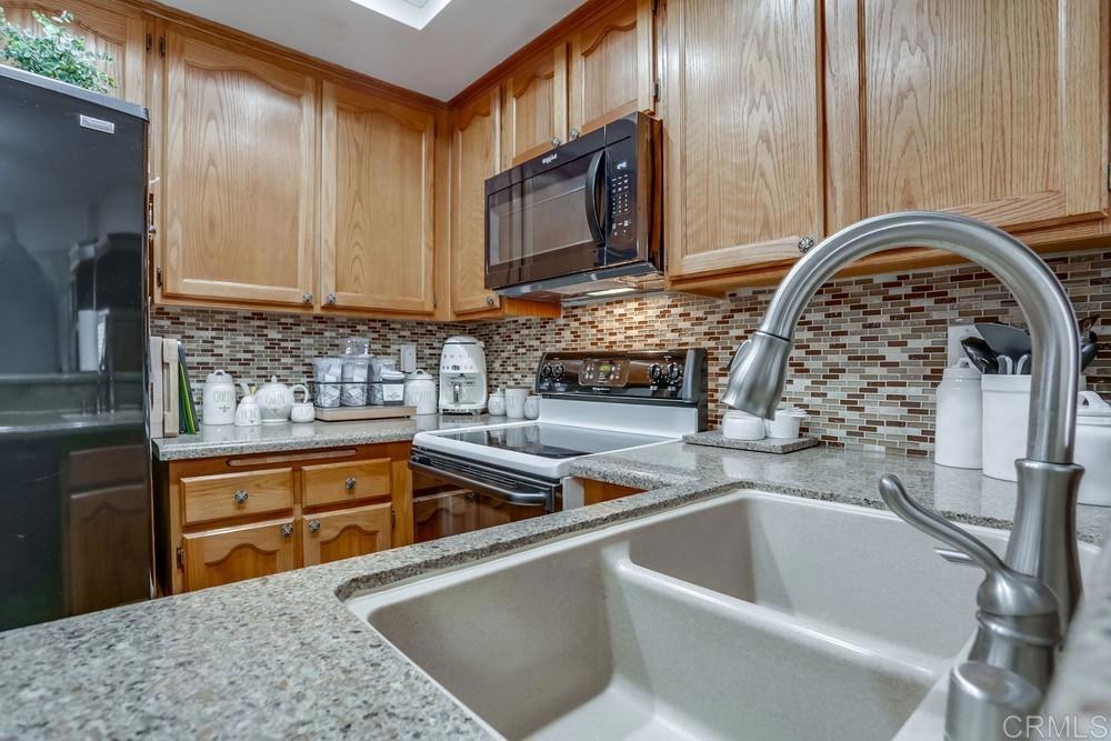 5875 Friars Road, Unit 4404 San Diego, CA 92110 - Photo 11 of 32 a kitchen with a sink a stove and cabinets