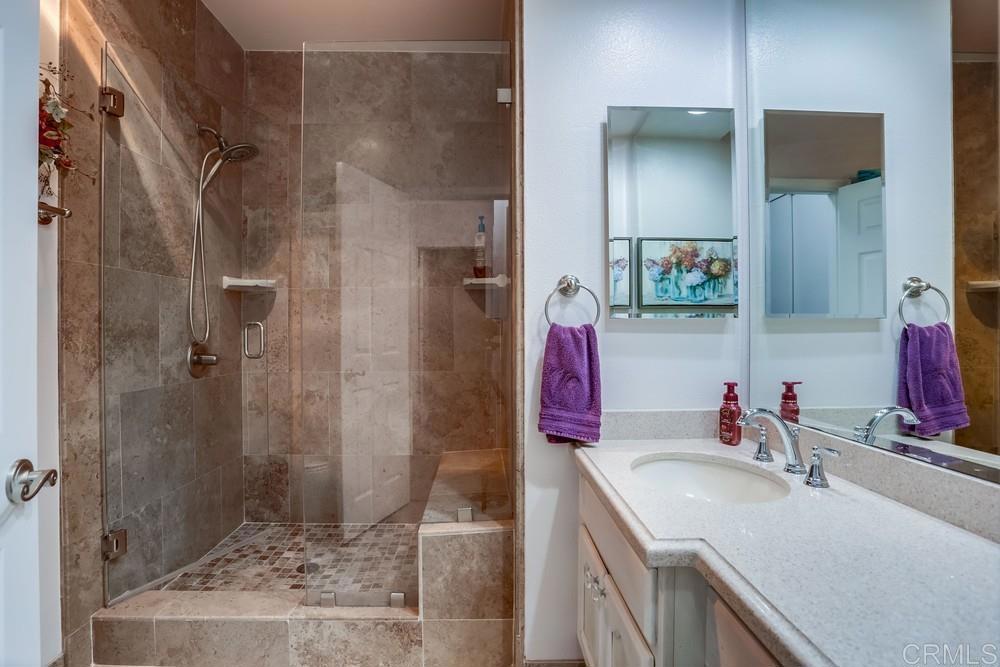 5875 Friars Road, Unit 4404 San Diego, CA 92110 - Photo 20 of 32 a bathroom with a sink vanity granite shower and a mirror
