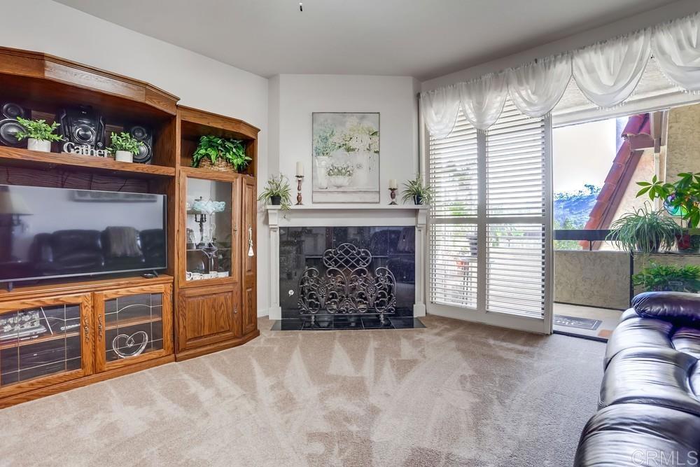 5875 Friars Road, Unit 4404 San Diego, CA 92110 - Photo 2 of 32 a living room with furniture a flat screen tv and a fireplace