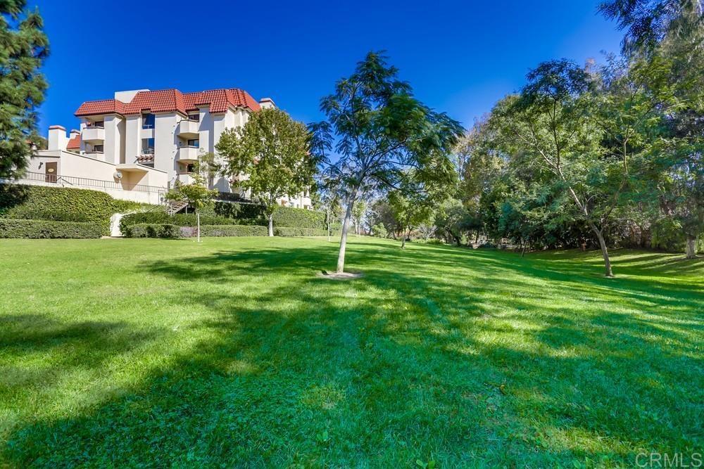 5875 Friars Road, Unit 4404 San Diego, CA 92110 - Photo 27 of 32 a front view of a multi story residential apartment building with a yard