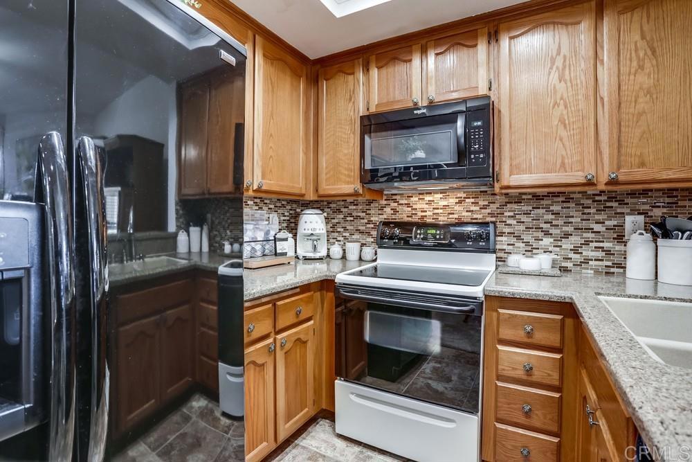 5875 Friars Road, Unit 4404 San Diego, CA 92110 - Photo 9 of 32 a kitchen with a stove microwave and refrigerator