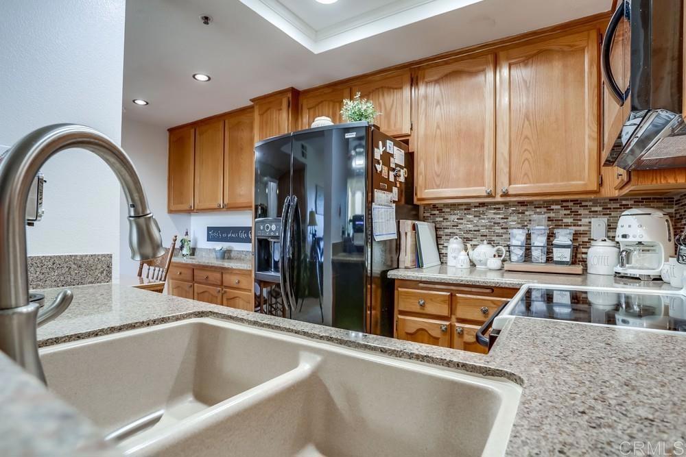 5875 Friars Road, Unit 4404 San Diego, CA 92110 - Photo 10 of 32 a kitchen with stainless steel appliances granite countertop a sink a stove and a refrigerator