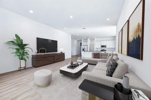 a living room with furniture a flat screen tv and a potted plant