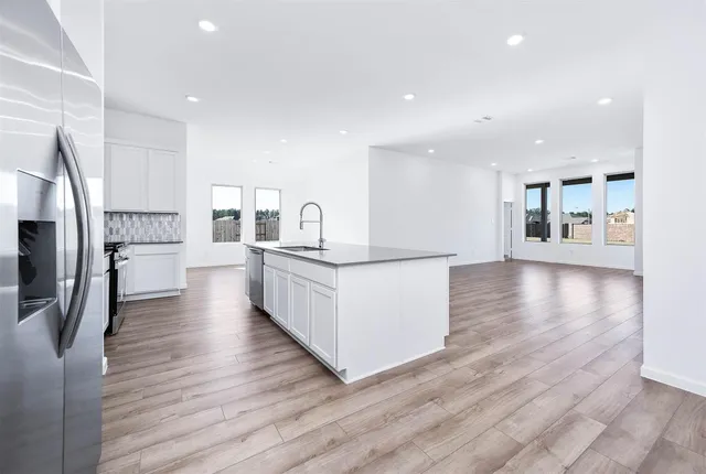 a view of a kitchen with wooden floor and a refrigerator