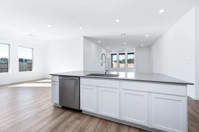 a kitchen with white cabinets granite counter tops and a window