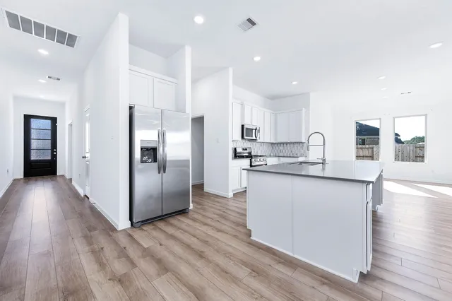 a kitchen with stainless steel appliances granite countertop a refrigerator and a stove top oven