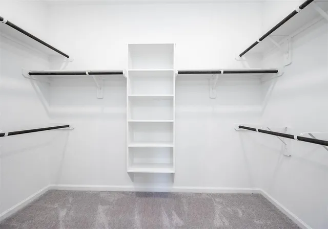 a view of walk in closet with empty racks
