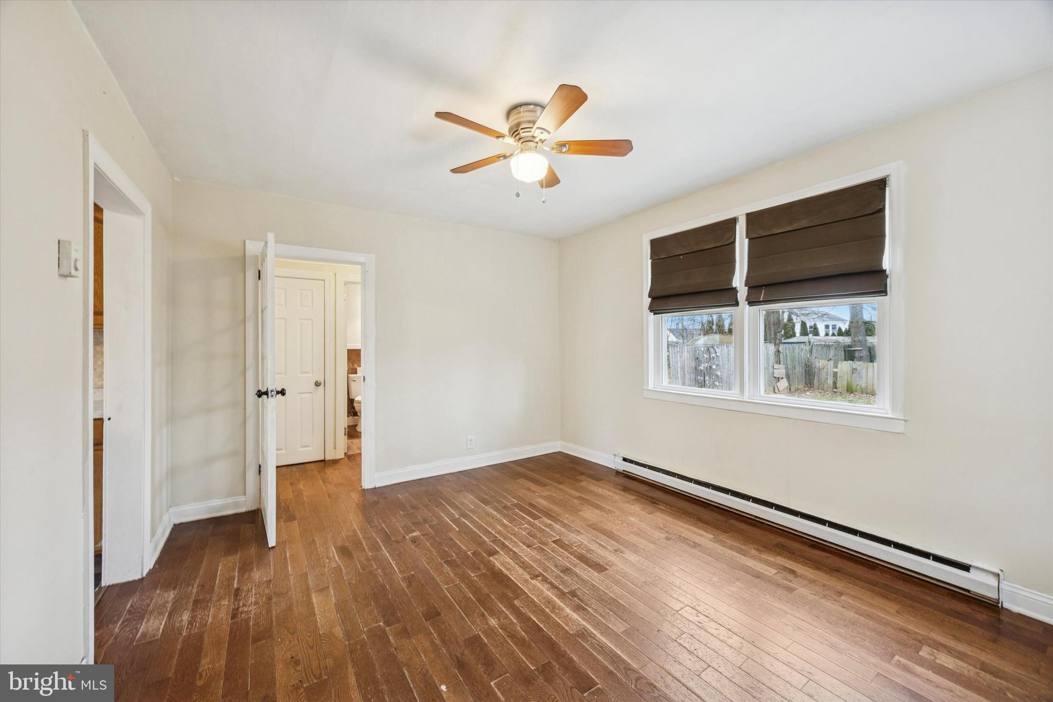 403 Denver Court Wallingford, PA 19086 - Photo 3 of 13 a view of an empty room with wooden floor and a window