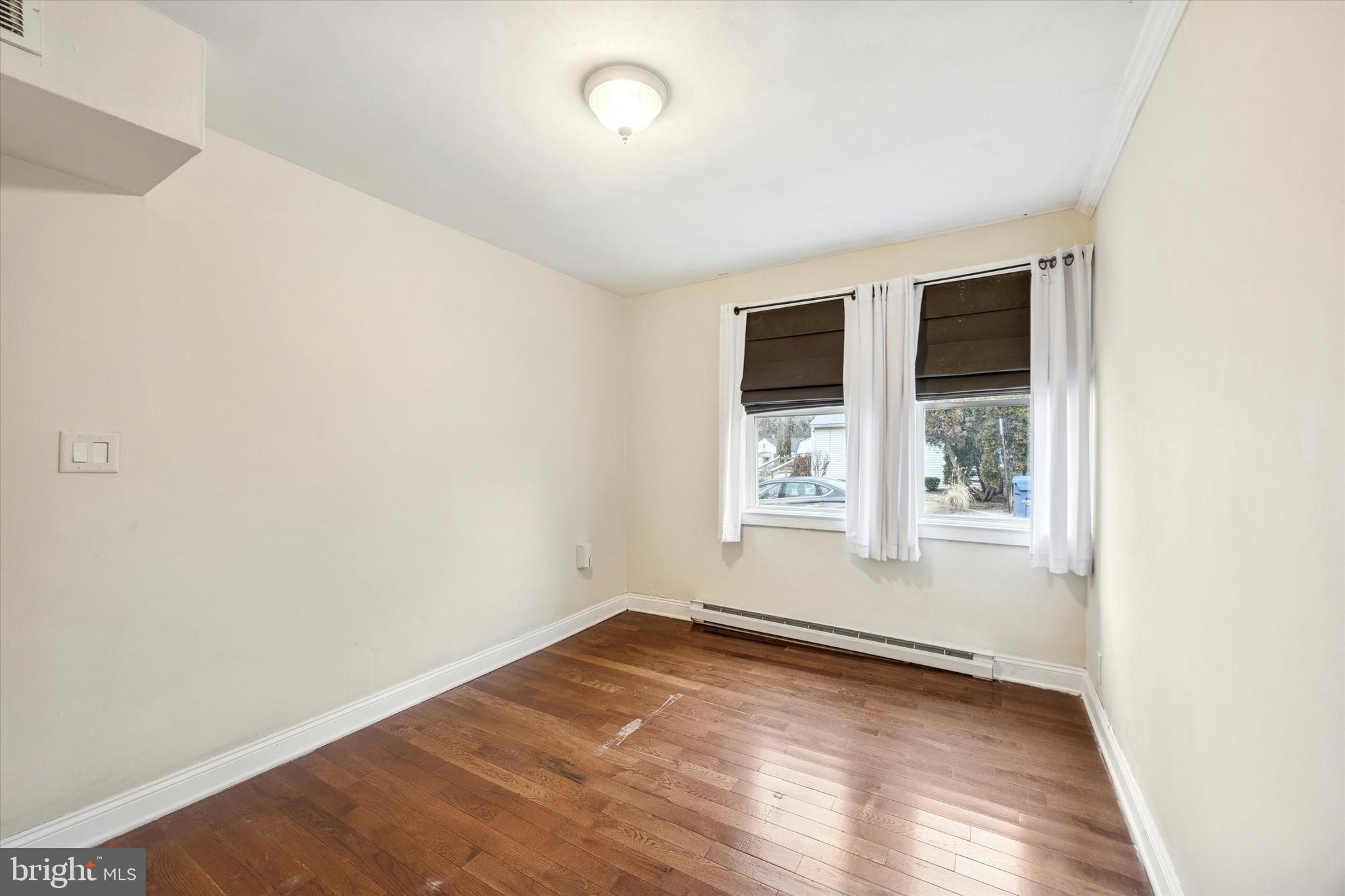 403 Denver Court Wallingford, PA 19086 - Photo 9 of 13 an empty room with wooden floor and windows