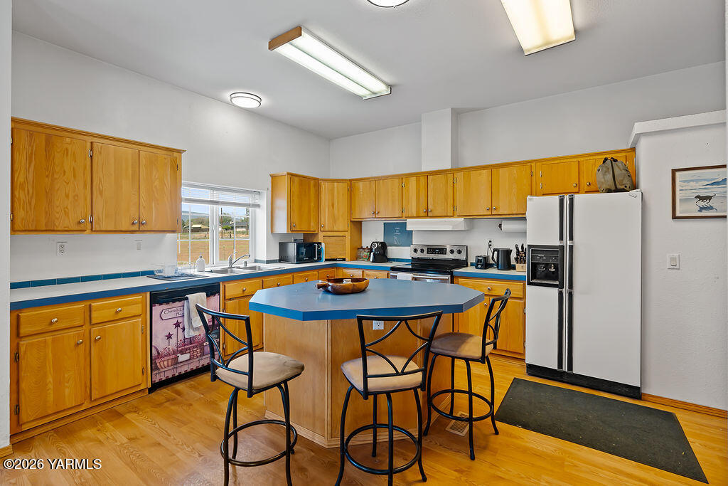 1550 Gibson Road Selah, WA 98942 - Photo 8 of 33 a kitchen with stainless steel appliances kitchen island granite countertop a table chairs sink and cabinets