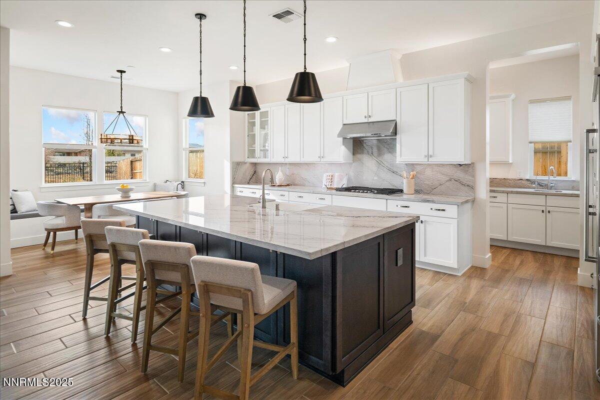2330 Blushing Rock Drive Reno, NV 89521 - Photo 11 of 60 a kitchen with wooden floor and white cabinets