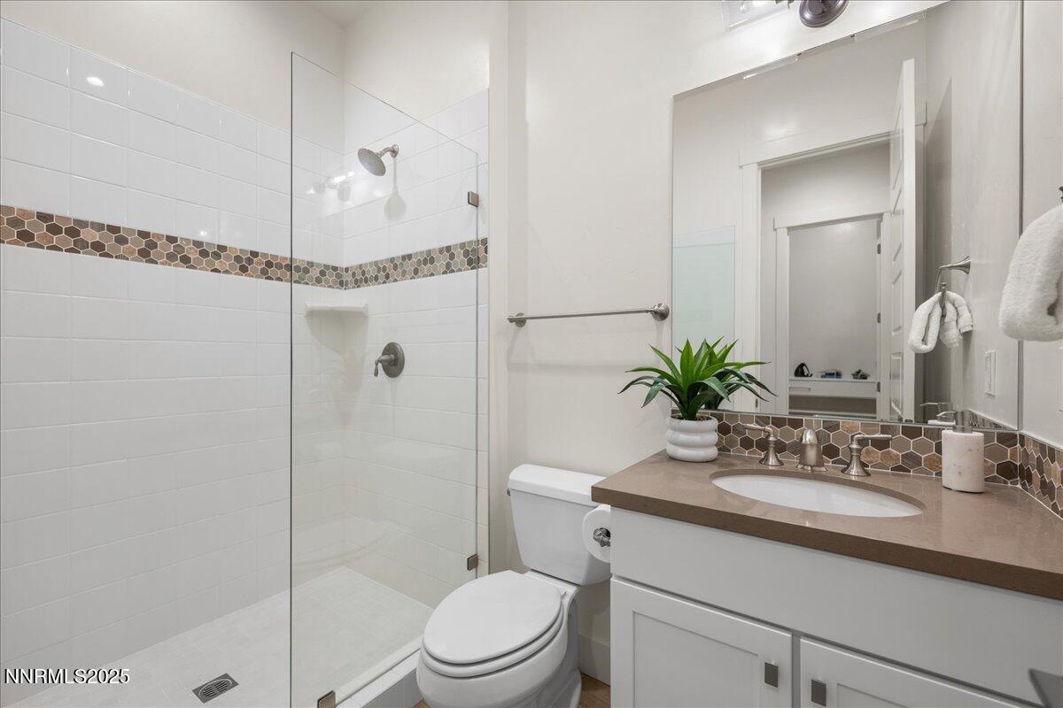 2330 Blushing Rock Drive Reno, NV 89521 - Photo 26 of 60 a bathroom with a granite countertop sink a toilet a mirror and shower