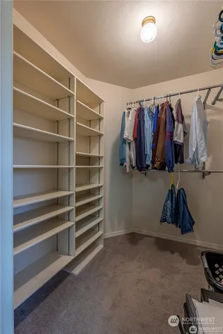 a view of walk in closet with clothes and shoes