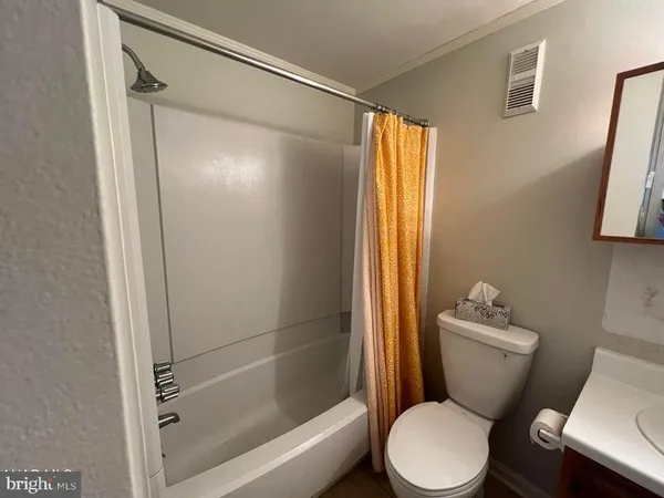 a white toilet sitting next to a bath tub
