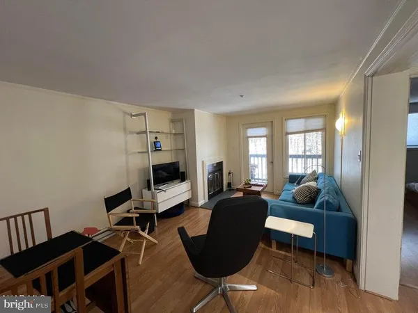 a living room with furniture wooden floor and a window