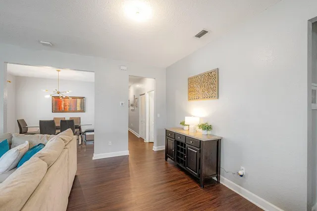 a living room with furniture and a wooden floor