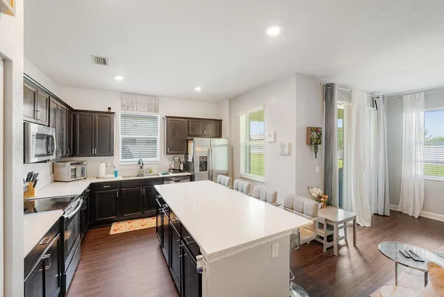 a kitchen with a sink a stove and chairs