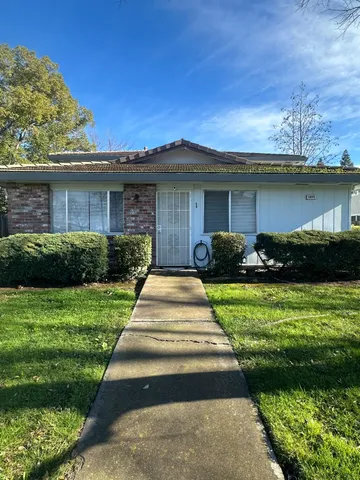 a front view of a house with a yard and potted plants