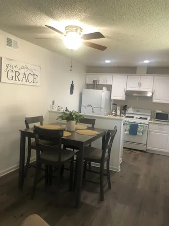a kitchen with a dining table chairs and stainless steel appliances